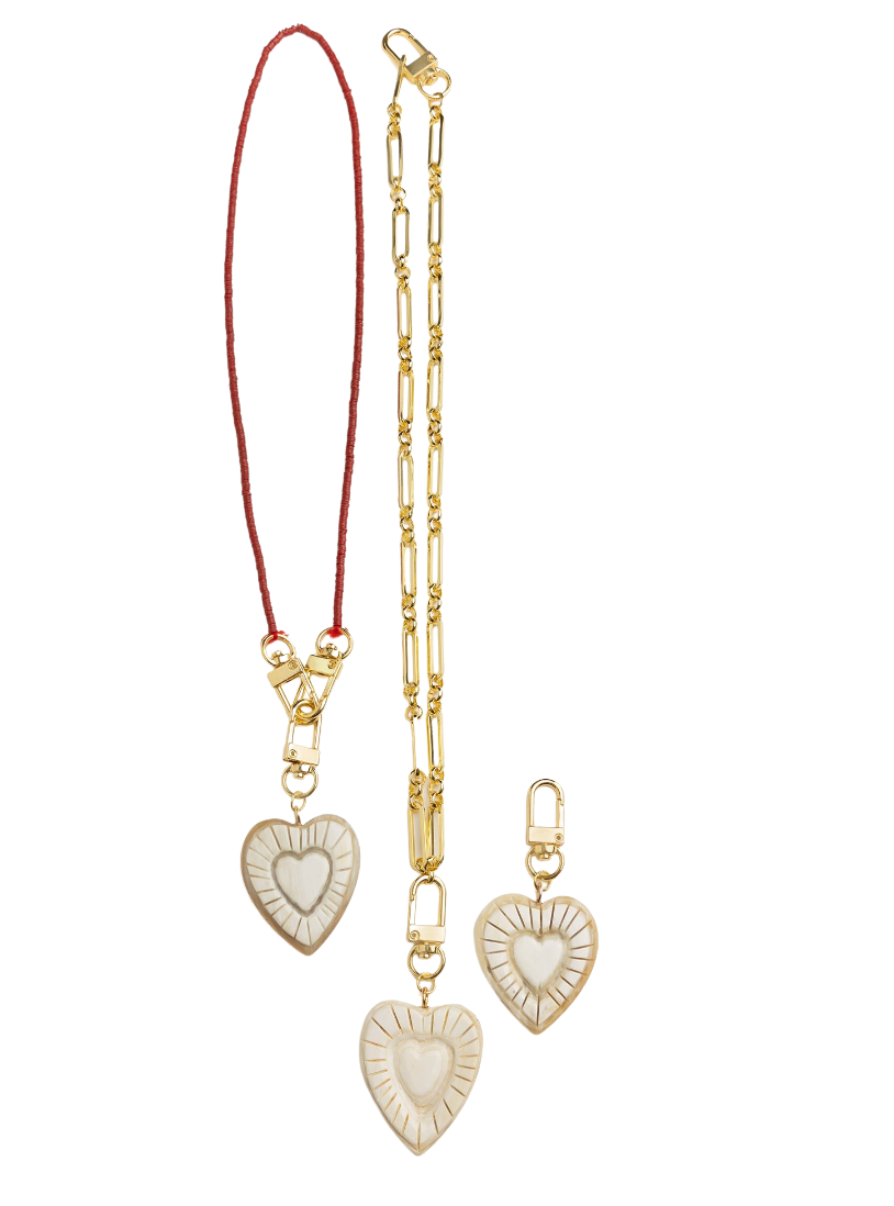 Gold heart-shaped pendant necklace with red cord on a white background