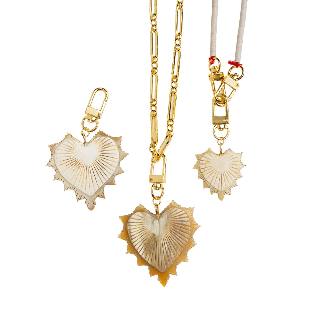 Gold necklaces with heart-shaped shell pendants on a white background