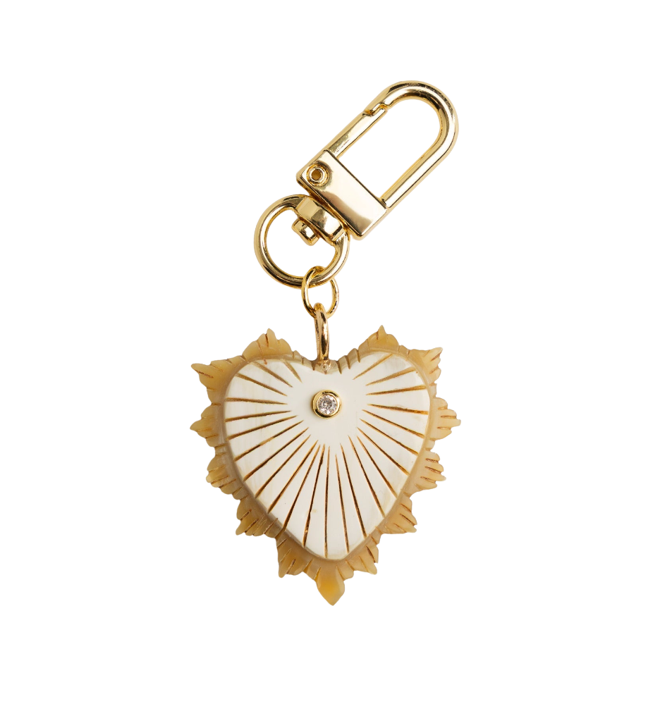 Heart-shaped charm with gold and white design on a white background