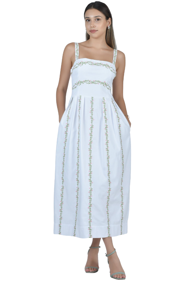Woman wearing a white dress with gold embroidery on a white background