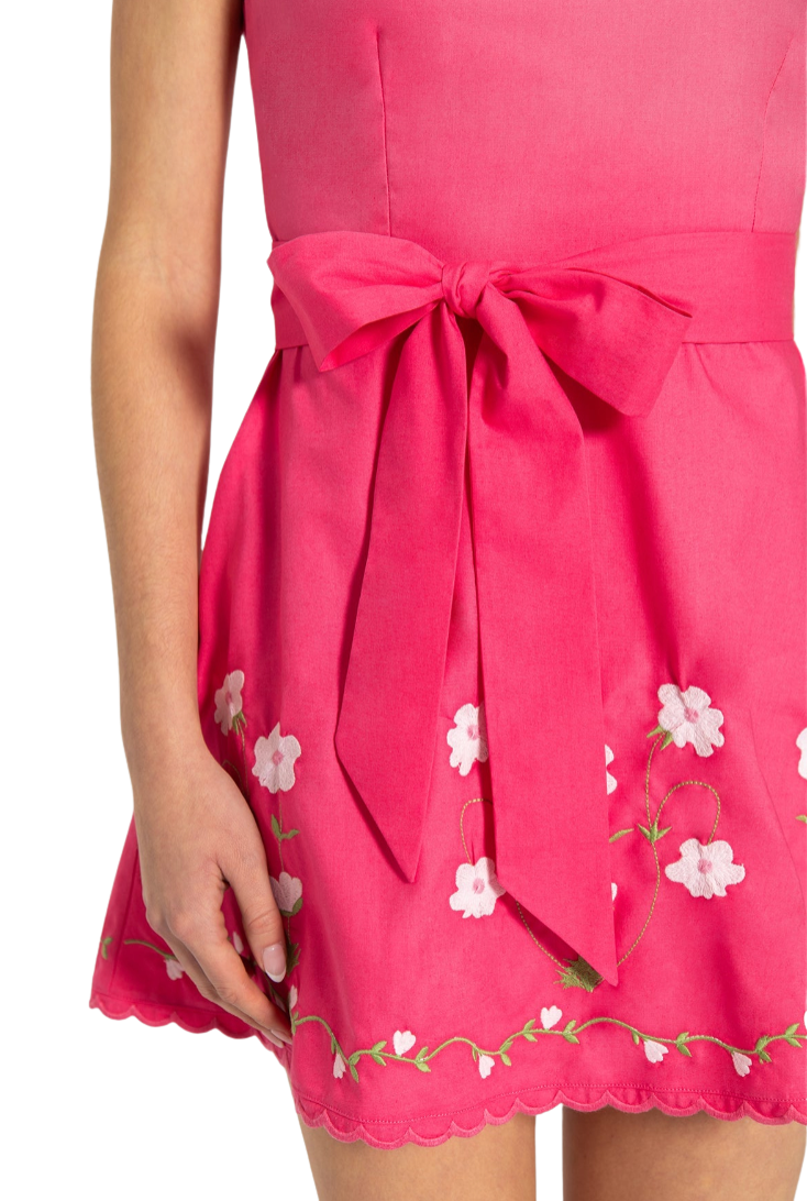 Pink dress with floral embroidery and a large bow on a white background