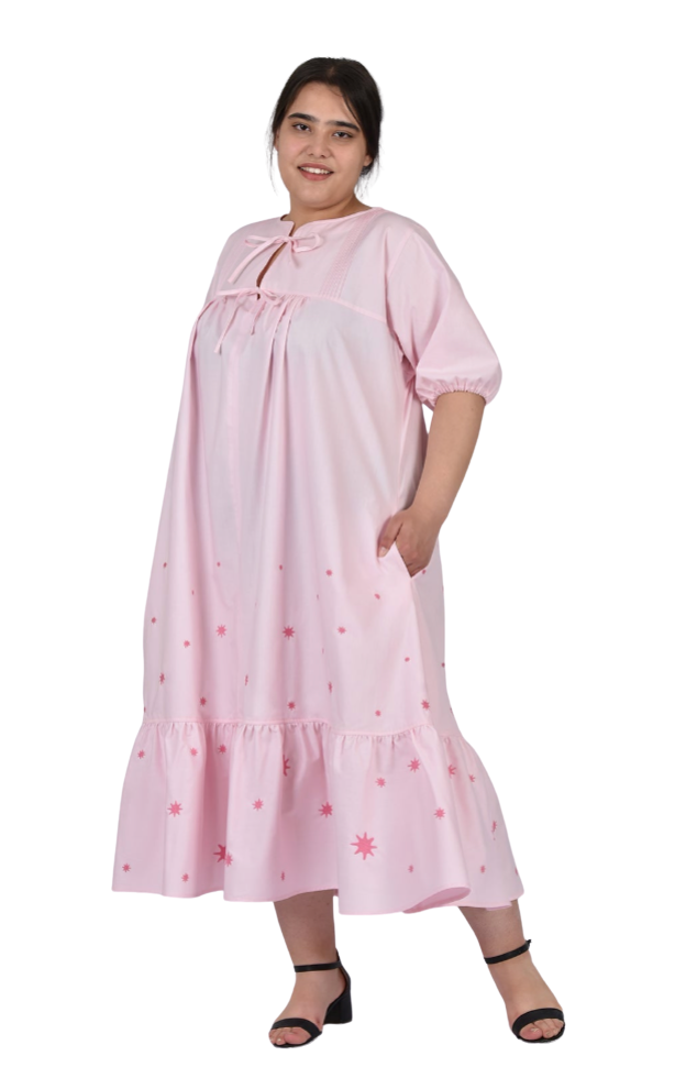 Woman wearing a pink nightgown with floral patterns on a white background
