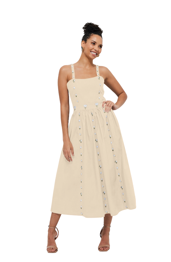 Woman wearing a yellow dress with floral details on a white background