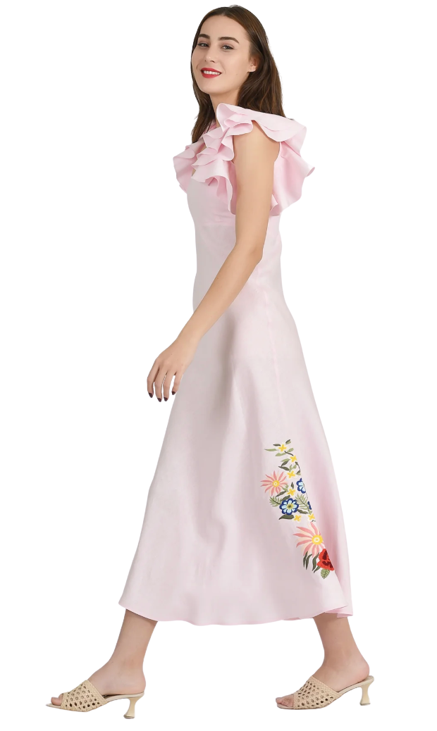 Woman wearing a light pink dress with floral embroidery on a white background