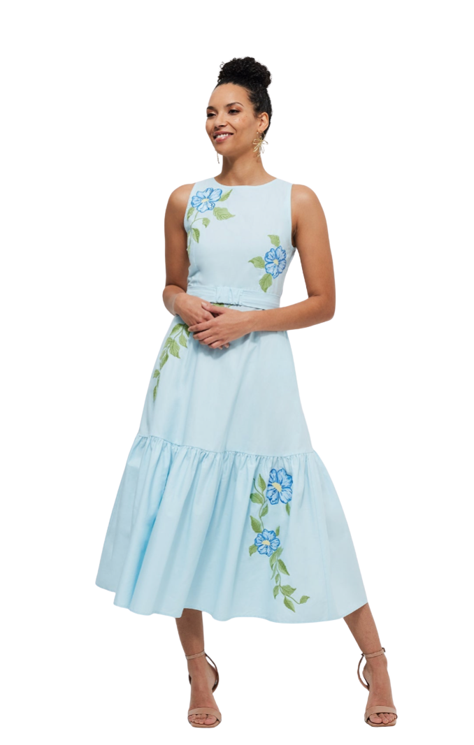 Woman wearing a light blue dress with floral embroidery on a white background