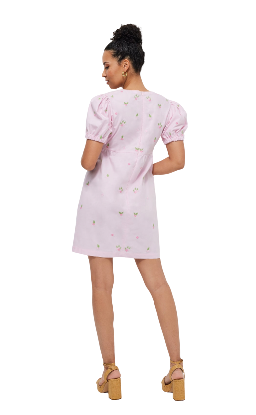 Woman wearing a pink dress with puff sleeves on a white background