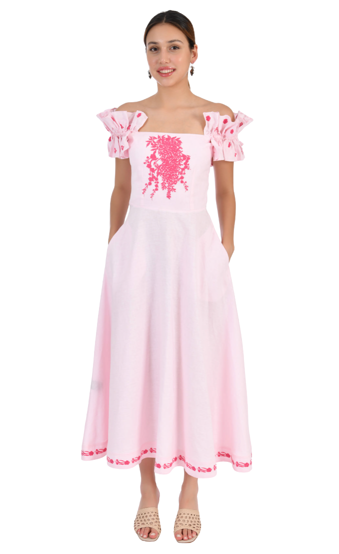 Woman wearing a pink dress with floral embroidery on a white background