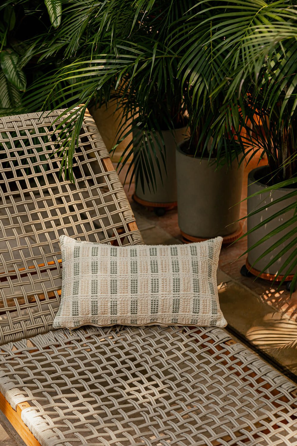 Decorative pillow cover in two color options: Sage Green & Cream and Earth Brown & Cream. The cover measures 30 x 50 cm (12 x 20 inches) and is crafted from 100% organic cotton, featuring both undyed and naturally dyed handspun and industrially spun yarn. A golden metal zipper pull adds a touch of elegance. The back is made from plain weave organic cotton in natural cotton. Insert not included. Handmade by a women artisan cooperative in Charalá, Colombia.