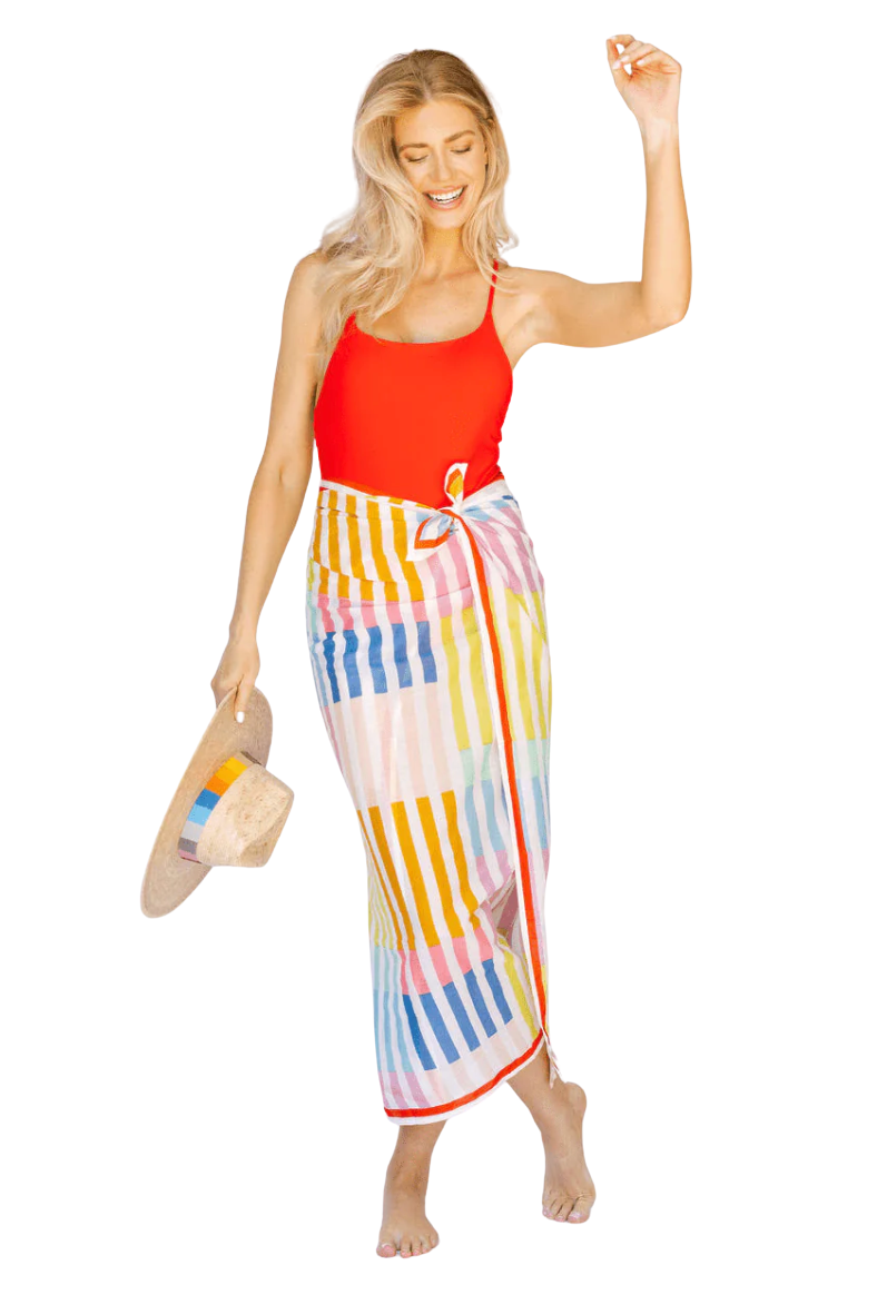 Woman wearing a red top and colorful striped skirt on a white background