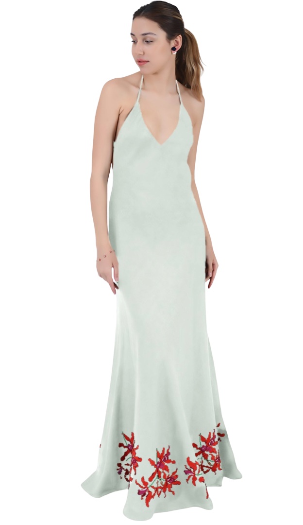 Woman wearing a light green dress with red floral embroidery on a white background
