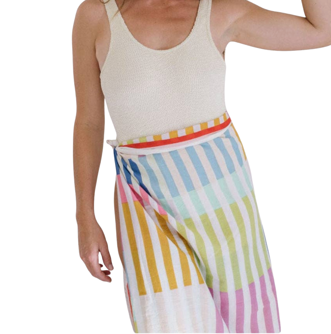 Person wearing a colorful striped skirt with a plain background
