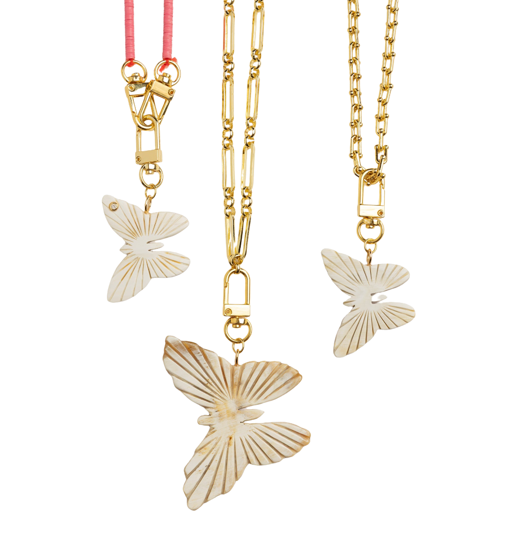 Butterfly-shaped pendants on gold chains with a white background