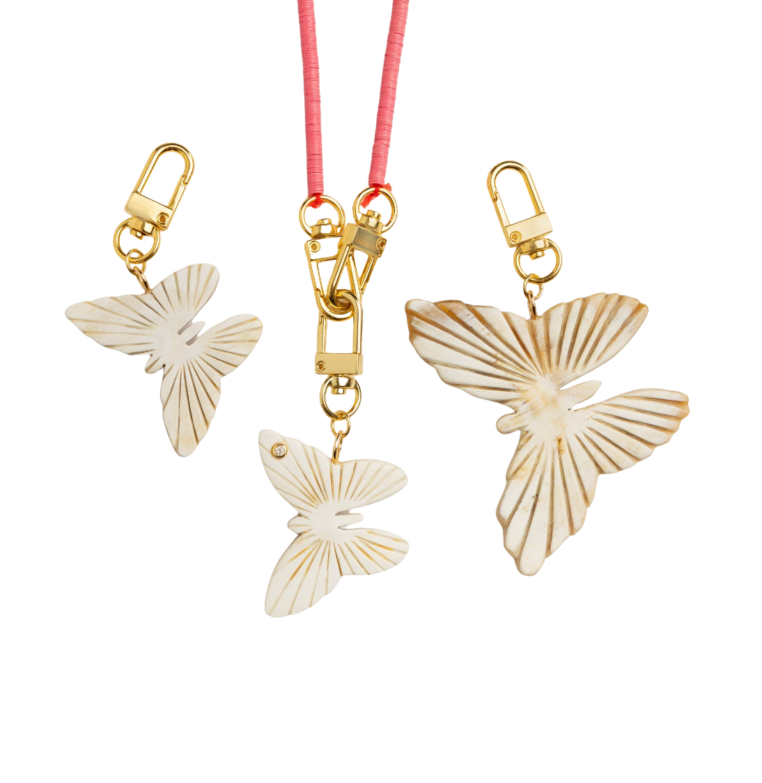 Butterfly-shaped charms with gold clasps on a white background
