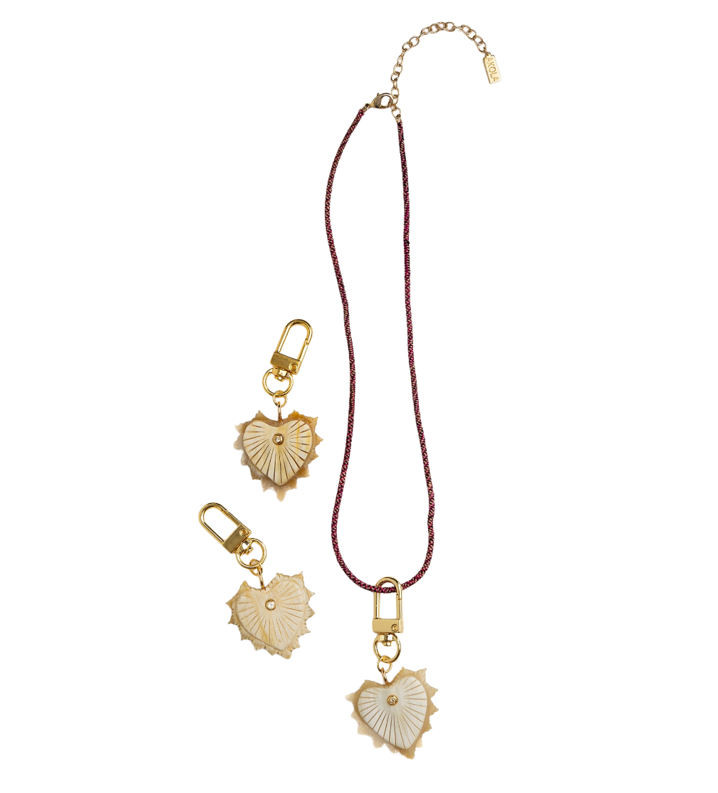 Gold heart-shaped charms on a red cord against a white background