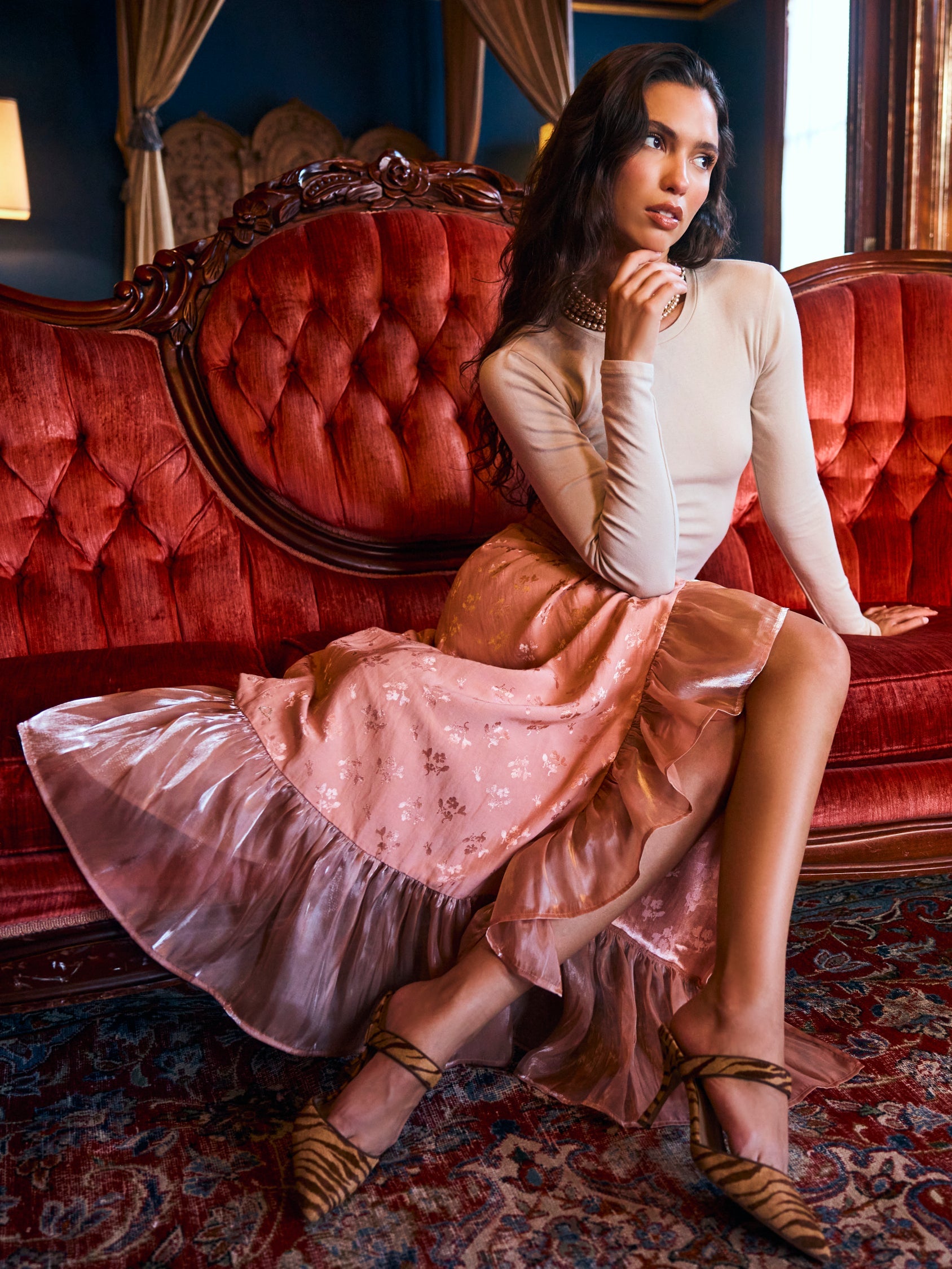 Blush pink embroidered midi wrap skirt with cascading ruffles and asymmetrical hem, shown on model with white top and kitten heels