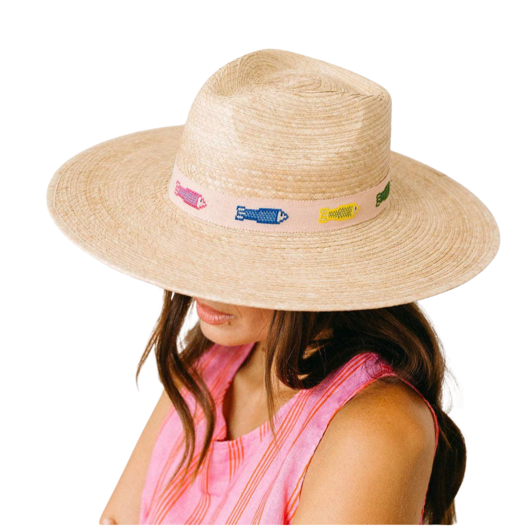 Beige straw hat with colorful band worn by a person on a white background