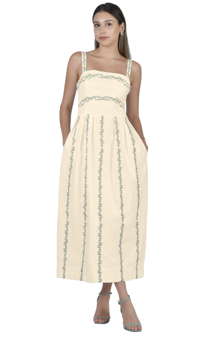 Woman wearing a beige dress with green patterns on a white background