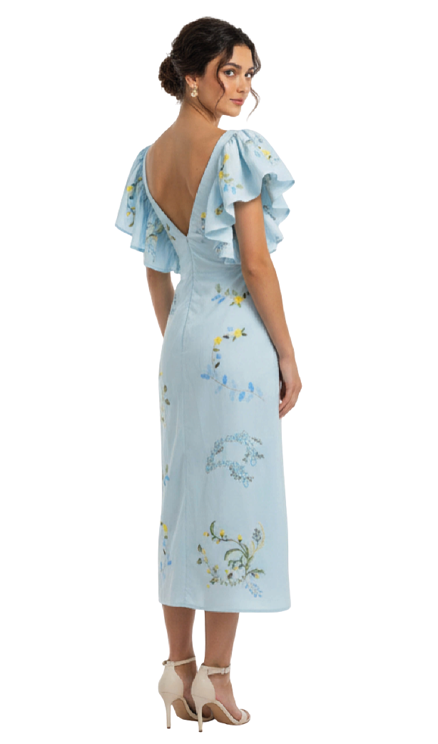 Woman wearing a light blue dress with floral embroidery on a white background