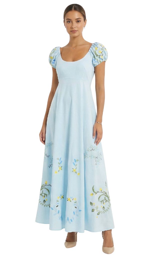 Woman wearing a light blue dress with floral embroidery on a white background