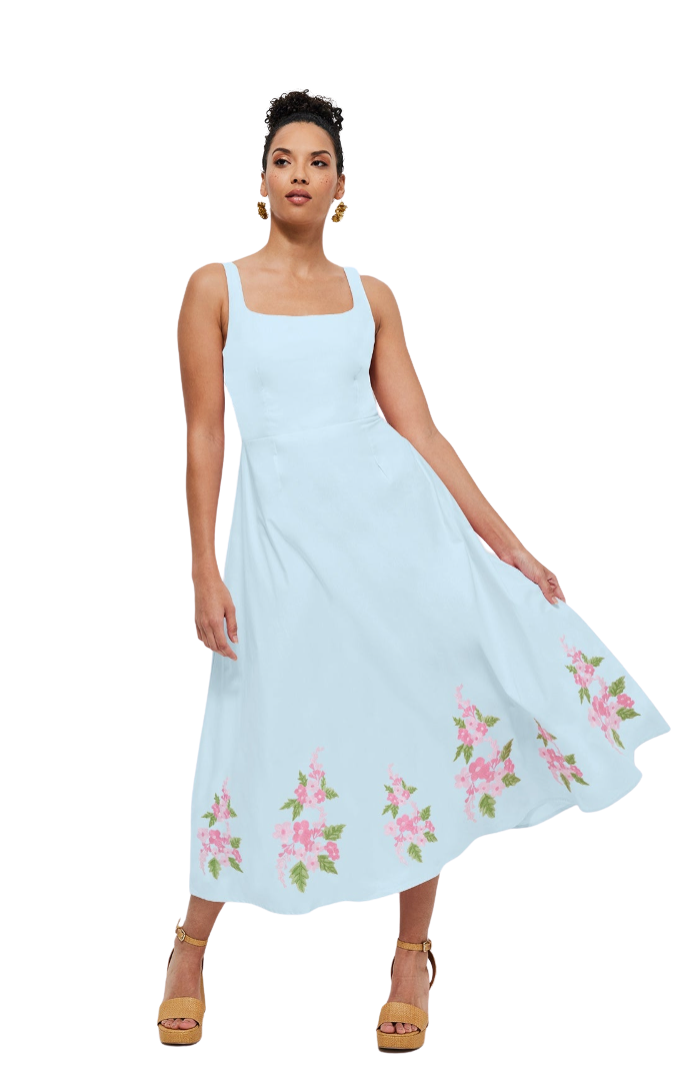 Woman wearing a light blue dress with floral embroidery on a white background