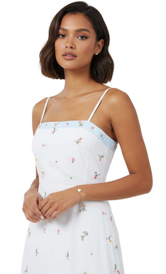 Woman wearing a white dress with floral pattern and thin straps on a white background