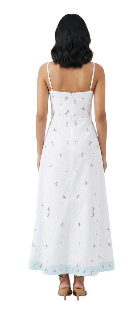 Woman wearing a white dress with floral patterns on a white background