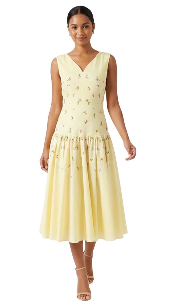 Woman wearing a light yellow sleeveless dress with floral embroidery on a white background