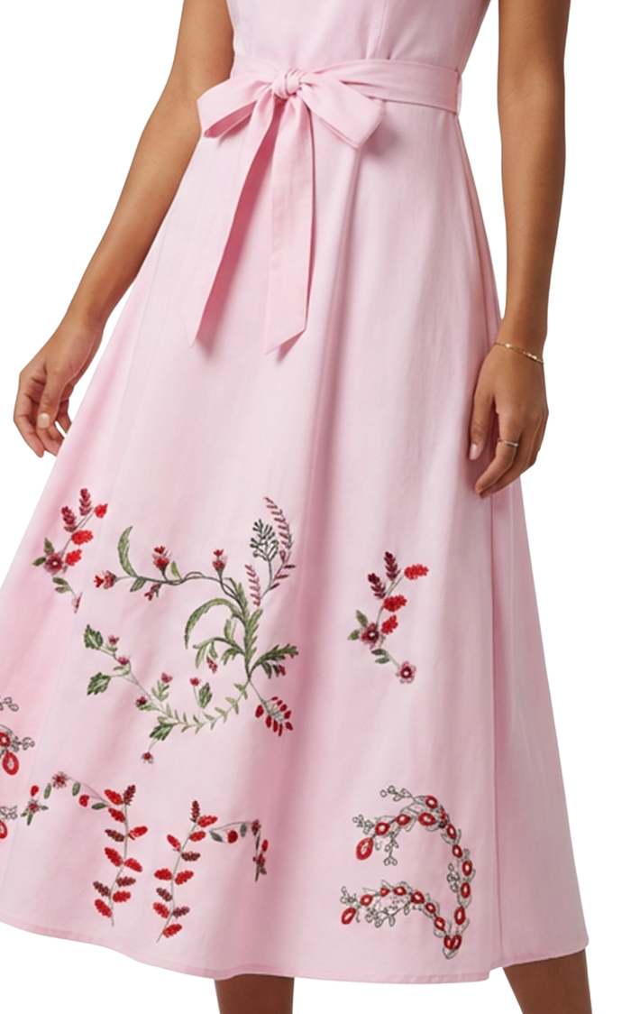 Pink dress with floral embroidery on a white background