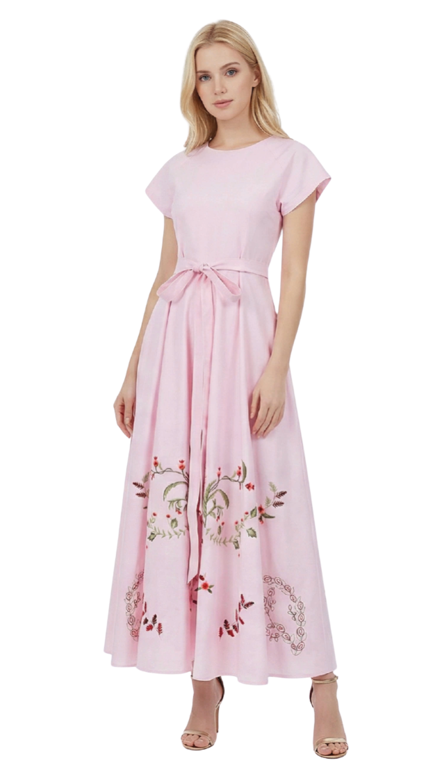 Woman wearing a pink dress with floral embroidery on a white background