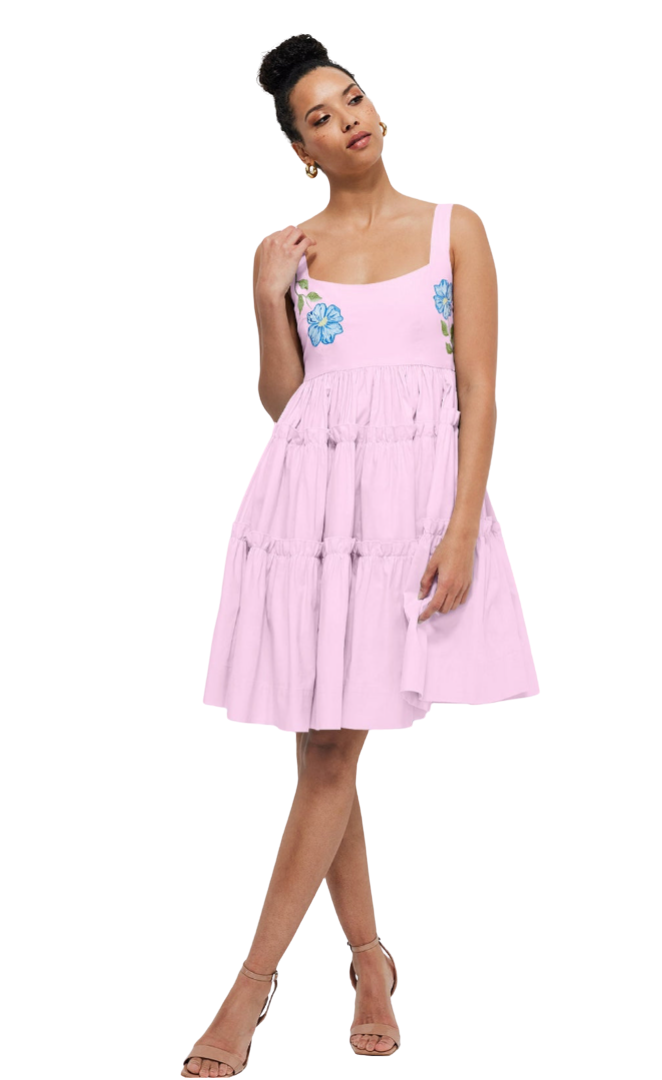Woman wearing a pink dress with floral designs on a white background