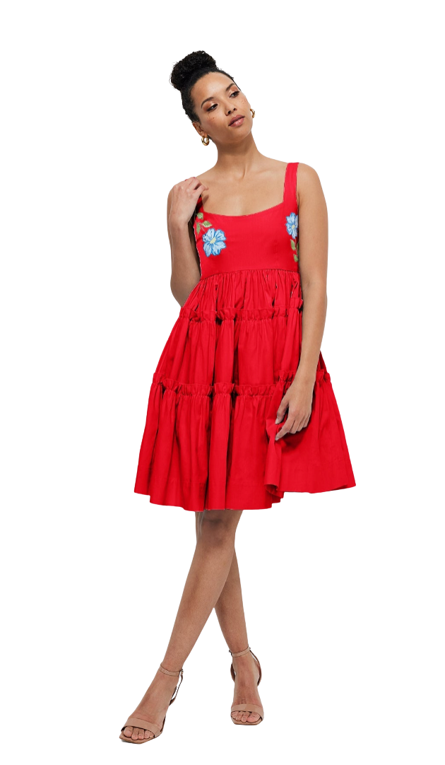 Woman wearing a red dress with floral details on a white background