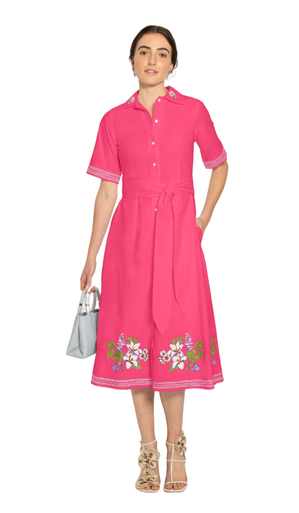 Woman wearing a pink dress with floral embroidery on a white background