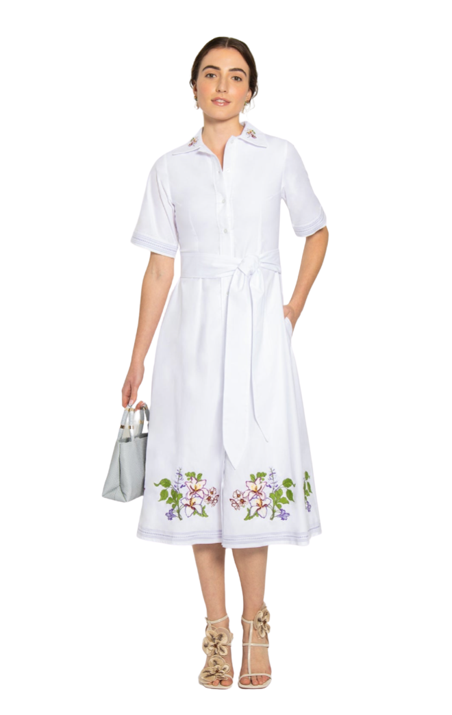 Woman wearing a white dress with floral embroidery on a white background