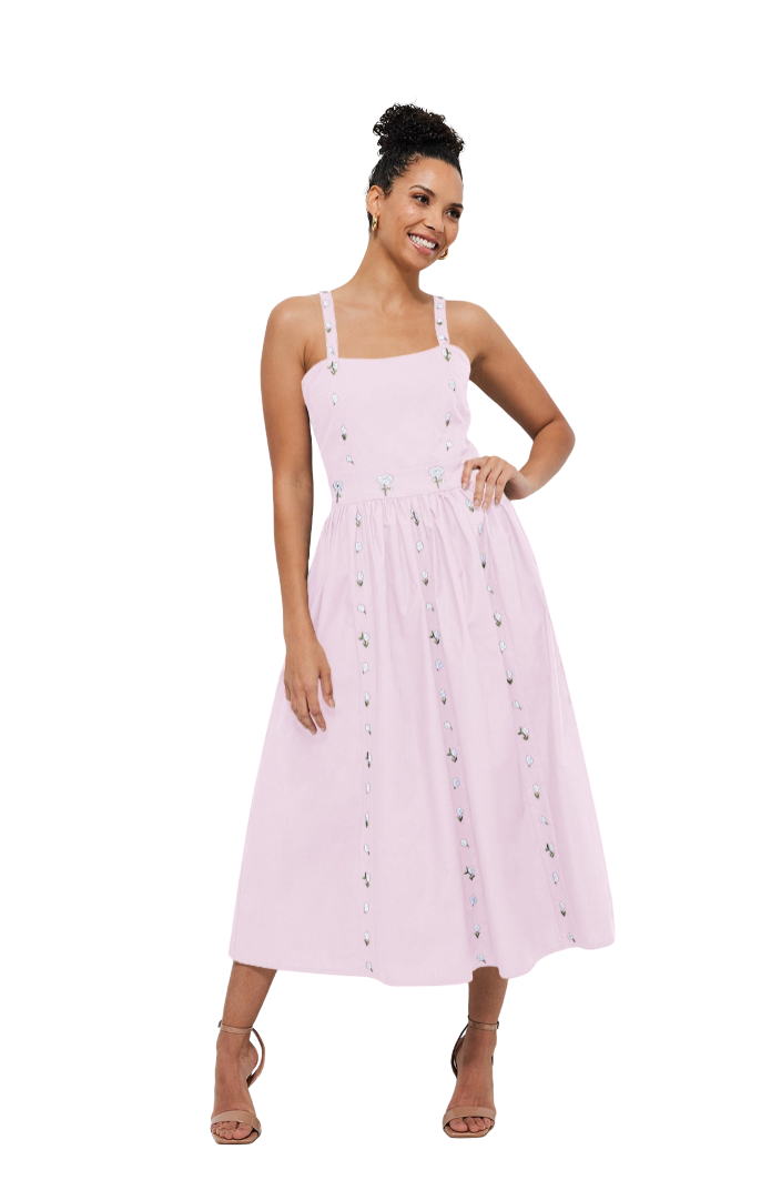 Woman wearing a light pink dress with thin straps on a white background