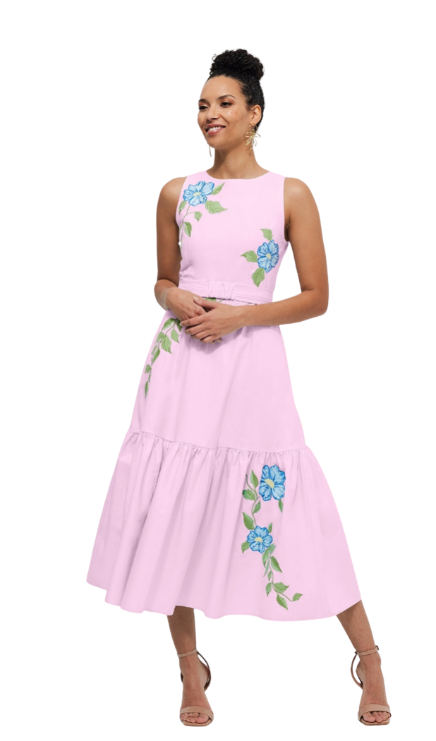 Woman wearing a pink dress with floral embroidery on a white background