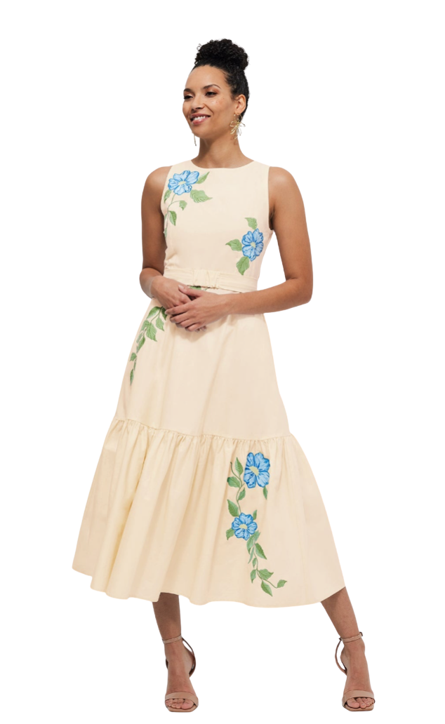 Woman wearing a beige dress with floral embroidery on a white background