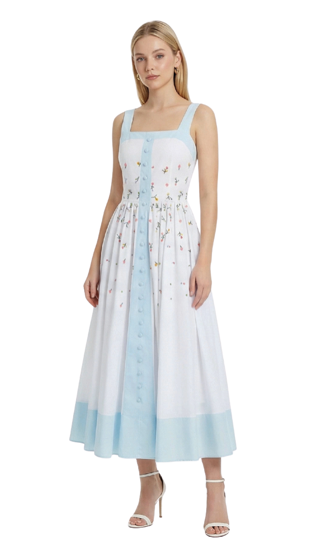 Woman wearing a sleeveless dress with a floral pattern and light blue accents on a white background