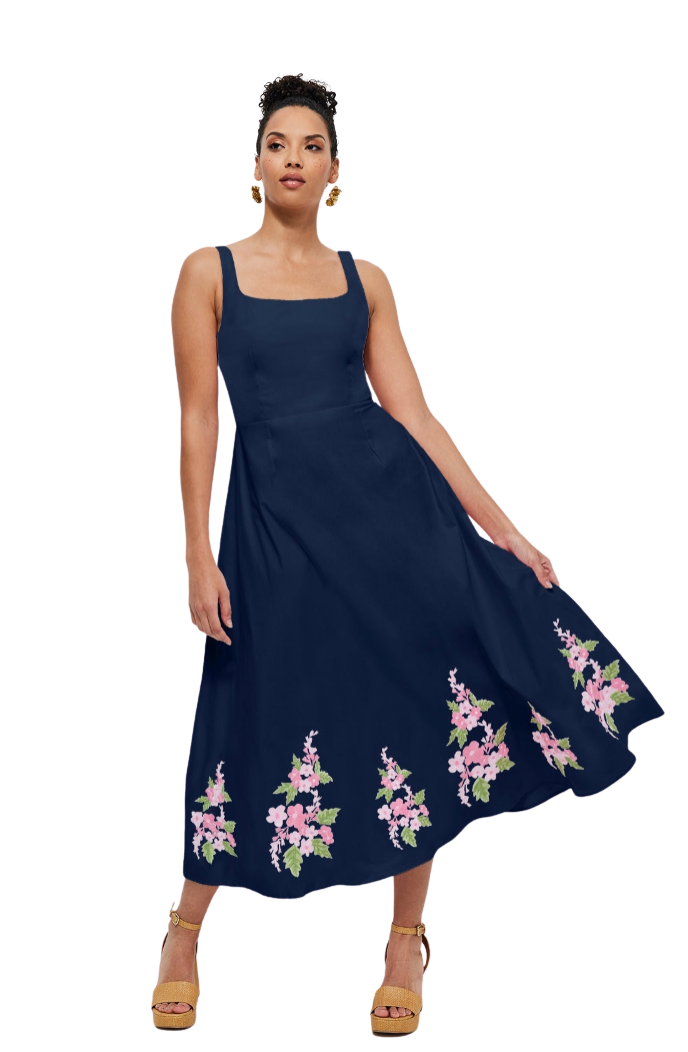 Woman wearing a navy blue dress with floral embroidery on a white background