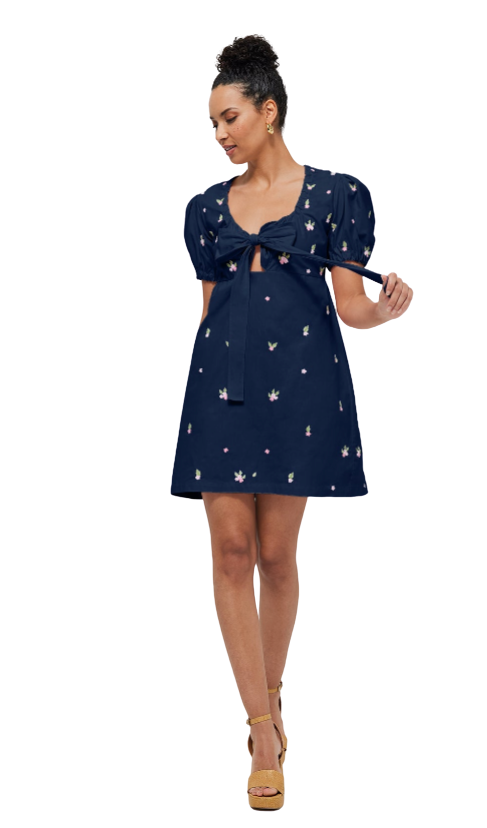 Woman wearing a navy blue dress with puff sleeves on a white background