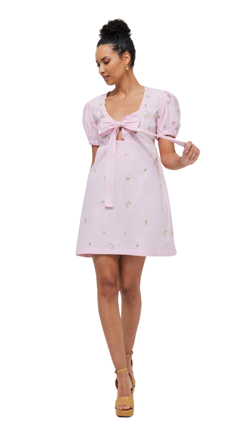Woman wearing a pink dress with puff sleeves on a white background