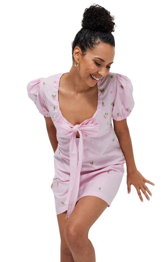 Woman wearing a pink dress with puff sleeves on a white background