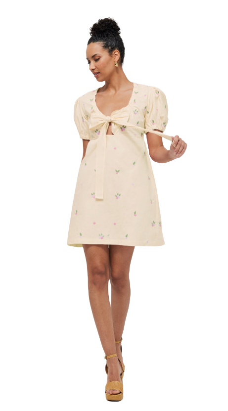 Woman wearing a cream-colored dress with puff sleeves on a white background