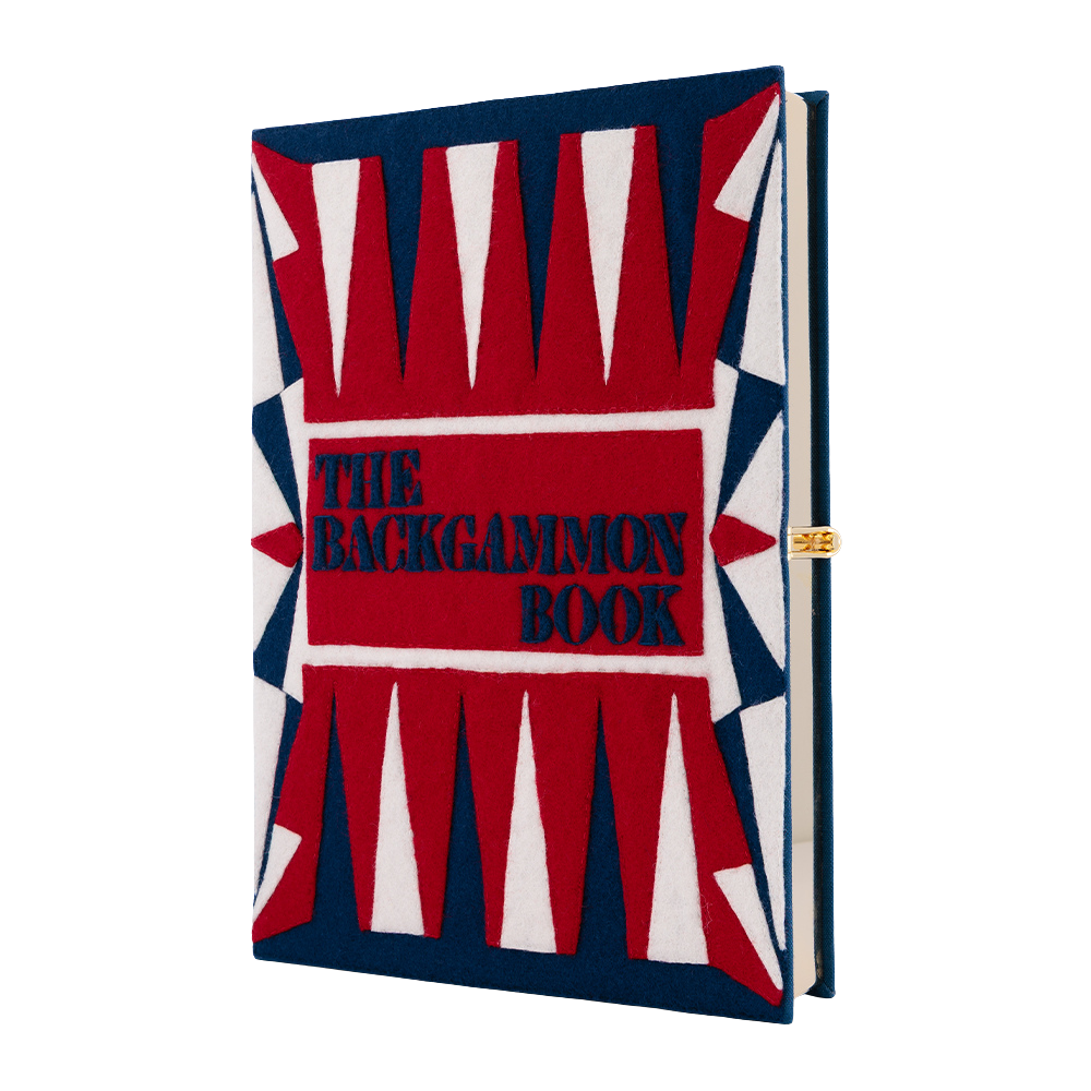 The Backgammon Book with a bold red, white, and navy blue geometric cover design, featuring the title 'THE BACKGAMMON BOOK' in navy blue text on a red background.