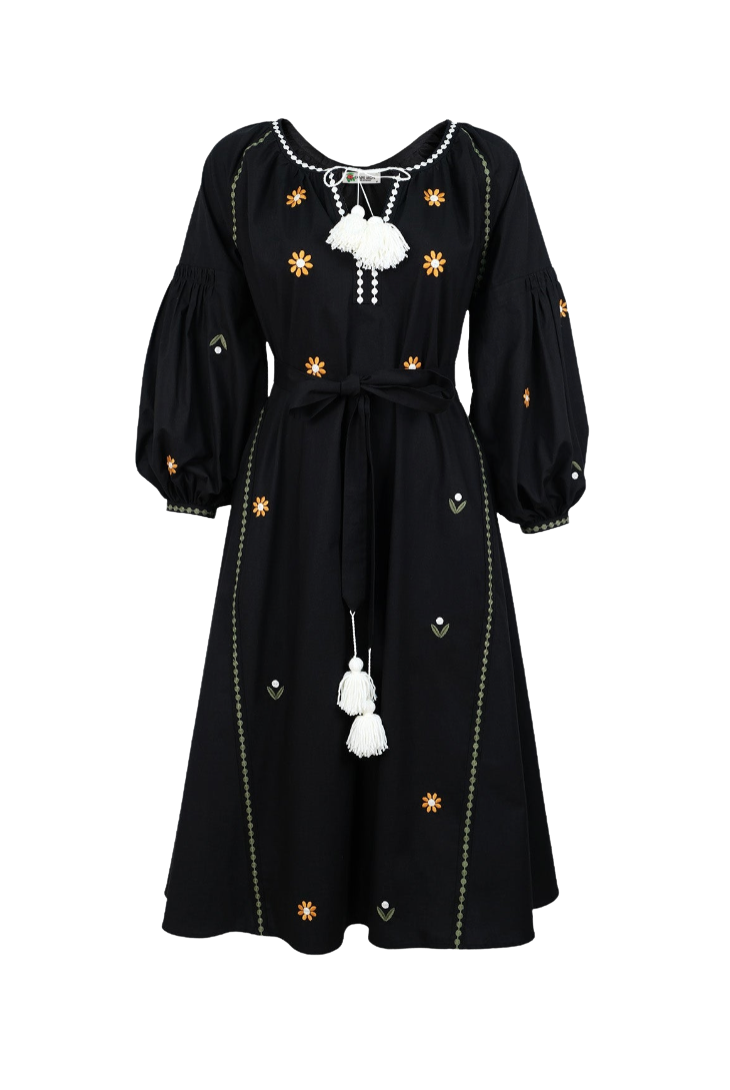 A black long-sleeve midi dress with puff sleeves, featuring embroidered yellow flowers, green geometric accents, and white tassel details, shown against a plain white background.