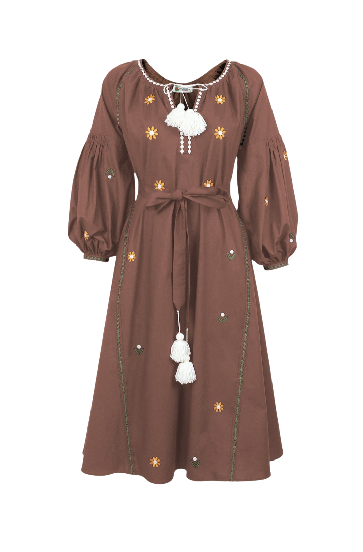 A brown long-sleeve midi dress with embroidered yellow and white floral details, a tie-neck with white tassels, and a matching waist tie, shown against a plain white background.