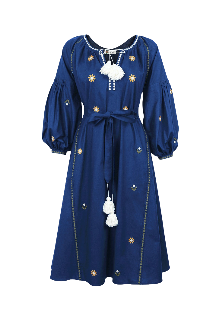 A navy blue midi dress with long balloon sleeves, a tie waist belt, and embroidered sun motifs with white tassel accents, shown against a plain white background.