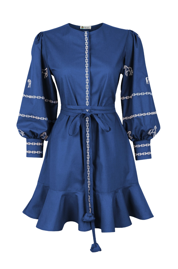 A royal blue long-sleeve dress with white embroidered details, featuring a tie waist belt and a ruffled hem, shown against a plain white background.