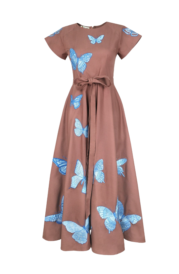 A dusty rose maxi dress with short sleeves, a tie waist, and a blue butterfly print, shown against a plain white background.