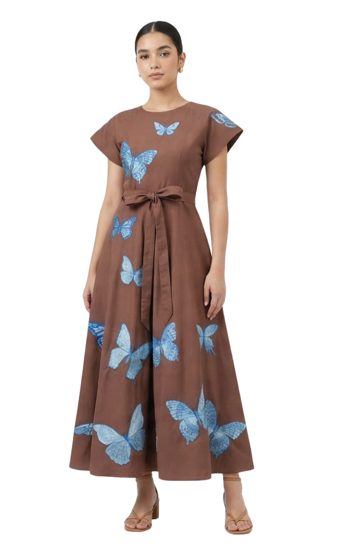 A woman modeling a brown short-sleeve maxi dress with a waist tie and blue butterfly print, set against a plain white studio background.
