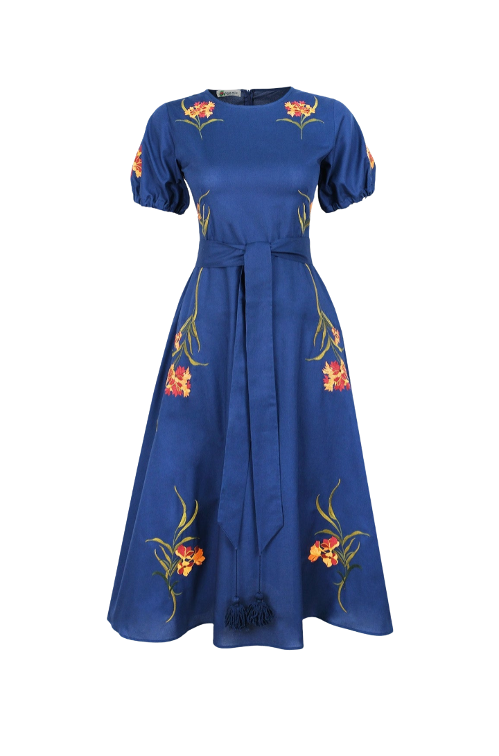 A royal blue midi dress with short puff sleeves, a matching waist tie, and vibrant floral embroidery in red, orange, and yellow with green stems. The dress is shown against a plain white background